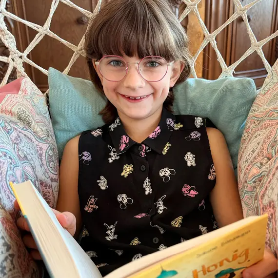 Kind mit Brille liest in einem Buch