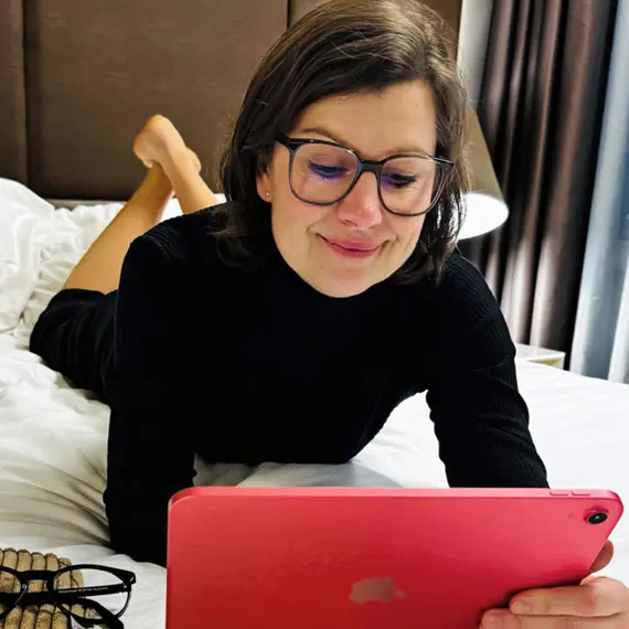 Frau mit einer Lesebrille am Tablet