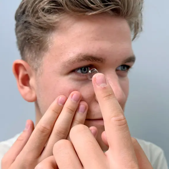 Mann setzt sich eine Monatslinse ein
